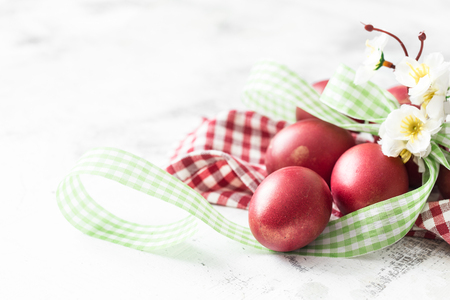 Easter background with red egg with flowers, the bright interior, the concept of the Easter holidaysの写真素材