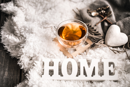 Composition with wooden white letters with the inscription home and a Cup of tea on a wooden background, the concept of home comfortの写真素材