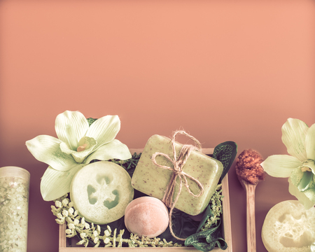 Spa composition with a variety of body care items on a colored background in a wooden box with a tropical leaf, Spa and body care conceptの写真素材