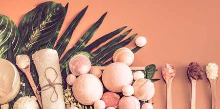 Spa composition with a variety of body care items on a colored background in a wooden box with a tropical leaf, Spa and body care conceptの写真素材