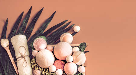 Spa composition with a variety of body care items on a colored background in a wooden box with a tropical leaf, Spa and body care conceptの写真素材