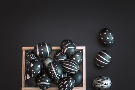 Easter eggs black and white handmade pattern in wooden box isolated on black background, Easter holidays conceptの写真素材