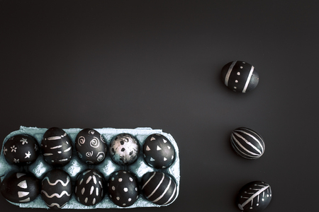 Easter eggs black and white pattern handmade in the tray isolated on a black background, the concept of the Easter holidaysの写真素材