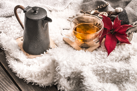 Composition with wooden white letters with the inscription home and a Cup of tea and a kettle on a wooden background, the concept of home comfortの写真素材