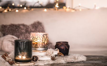 still life home atmosphere in the interior with candles and a book on the background of cozy bedspreads, home decor elements, the concept of comfort and cozinessの写真素材