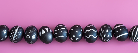 The Easter egg is black with light pattern and creative handmade , colorful pink background , the concept of the Easter holidaysの写真素材