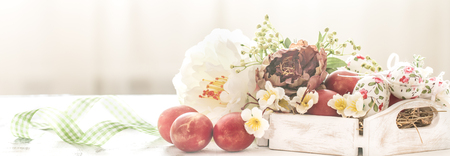 Easter background with a basket and red eggs with flowers, the bright interior, the concept of the Easter holidaysの写真素材