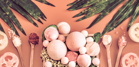 Spa composition with a variety of body care items on a colored background in a wooden box with a tropical leaf, Spa and body care conceptの写真素材