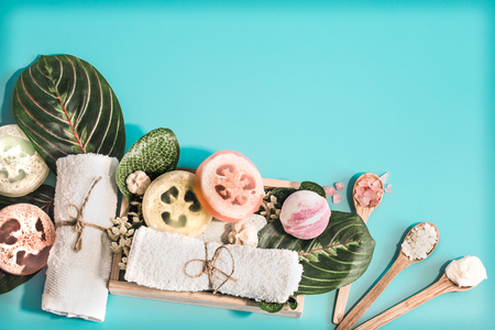 Organic Spa cosmetics, composition with soap and Spa care items on blue background with tropical leaf, Spa and body care conceptの写真素材