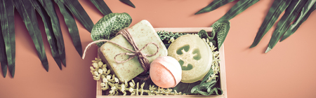 Spa composition with subjects of care of the body in a wooden box on a colored background with a tropical leaf , the concept of Spa and body careの写真素材