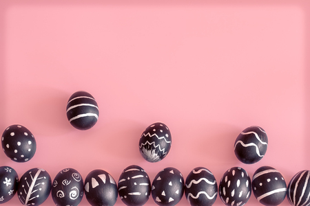 The Easter egg is black with light pattern and creative handmade , colorful pink background , the concept of the Easter holidaysの写真素材