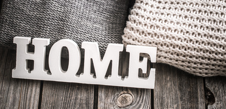 wooden decorative large white letters with home lettering and knitted sweaters white and gray on wooden backgroundの写真素材