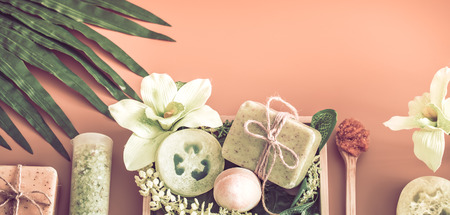 Spa composition with a variety of body care items on a colored background in a wooden box with a tropical leaf, Spa and body care conceptの写真素材