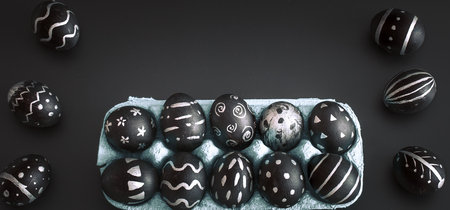 Easter eggs black and white pattern handmade in the tray isolated on a black background, the concept of the Easter holidaysの写真素材