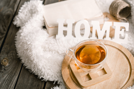 Composition with wooden white letters with the inscription home and a Cup of tea on a wooden background, the concept of home comfortの写真素材