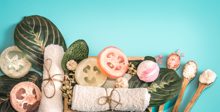 Organic Spa cosmetics, composition with soap and Spa care items on blue background with tropical leaf, Spa and body care conceptの写真素材