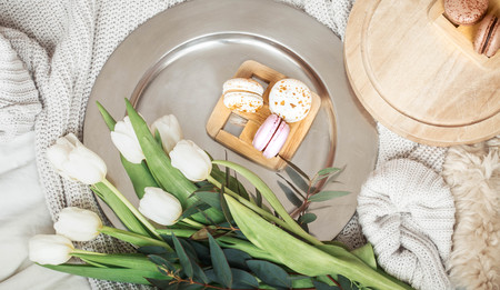 Still life with different macaroon on the background of the bed with white tulips, the concept of women's dayの写真素材