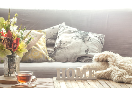 Homely cozy spring interior in the living room with a vase and flowers, home comfort conceptの写真素材