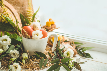 Happy Easter background. Easter egg in a nest with floral decoration near the window. Quail eggs. Happy Easter concept.の写真素材