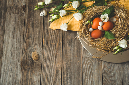 Happy Easter background. Easter eggs in a nest on a metal plate on a wooden background. Quail eggs. Happy Easter conceptの写真素材