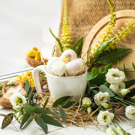 Happy Easter background. Easter egg in a nest with floral decoration near the window. Quail eggs. Happy Easter concept.の写真素材