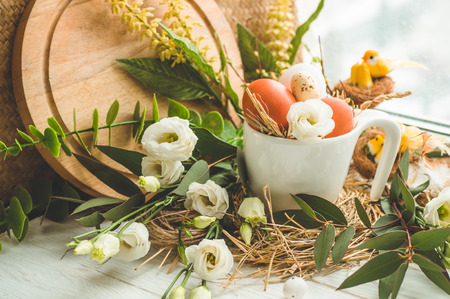 Happy Easter background. Easter egg in a nest with floral decoration near the window. Quail eggs. Happy Easter concept.の写真素材
