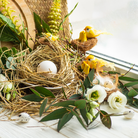 Happy Easter background. Easter egg in a nest with floral decoration near the window. Quail eggs. Happy Easter concept.の写真素材