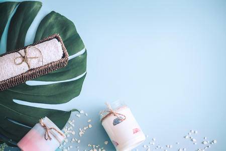 Composition of spa items on a color blue background with a tropical leaf, the concept of body care and spa treatmentsの写真素材
