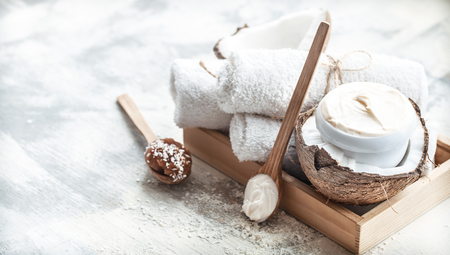 Spa still life with fresh coconut and body care products on light background, spa therapy conceptの写真素材