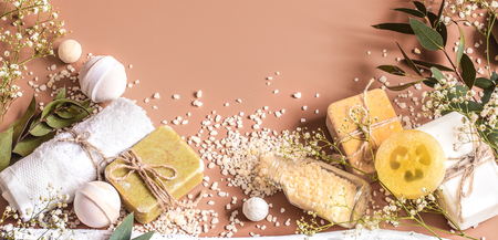 Spa concept with towels, soap, salt, leaves, flowers, bath bombs and body and face accessories on colored background. Place for textの写真素材