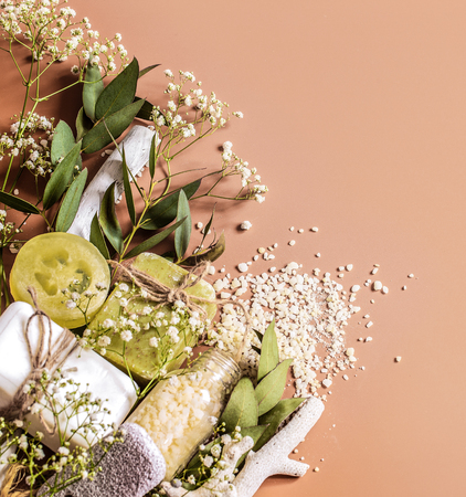 Spa concept with towels, soap, salt, leaves, flowers, bath bombs and body and face accessories on colored background. Place for textの写真素材