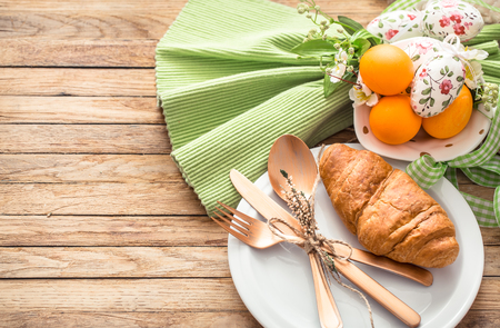 Easter breakfast with croissants and eggs on wooden backgroundの写真素材