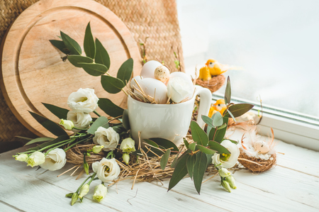 Happy Easter background. Easter egg in a nest with floral decoration near the window. Quail eggs. Happy Easter concept.の写真素材