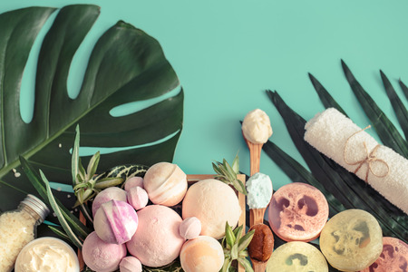 Still life of spa items on a colored background with tropical leaves, concept of body care and spa treatmentsの写真素材
