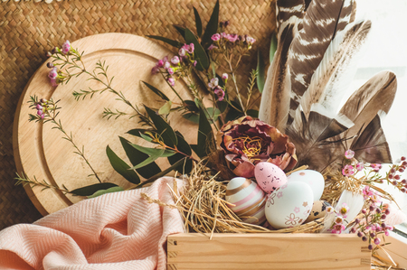 Happy Easter background. Pink Easter eggs in a nest with floral decorations and feathers near the window. Quail eggs. Happy Easter concept.の写真素材