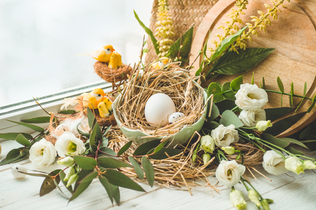 Happy Easter background. Easter egg in a nest with floral decoration near the window. Quail eggs. Happy Easter concept.の写真素材