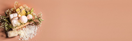 Spa or health plan frame with towels, soap, leaves, flowers, bath bombs and body and face accessories on colored background, see above. Place for textの写真素材