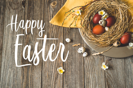 Happy Easter background. Easter eggs in a nest on a metal plate on a wooden background. Quail eggs. Happy Easter conceptの写真素材