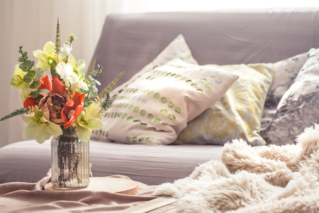 Homely cozy spring interior in the living room with a vase and flowers, home comfort conceptの写真素材