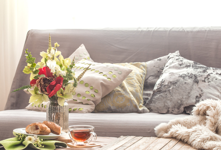 Homely cozy spring interior in the living room with a vase and flowers homemade breakfast, home comfort conceptの写真素材