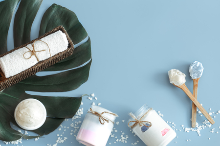 Composition of spa items on a color blue background with a tropical leaf, the concept of body care and spa treatmentsの写真素材