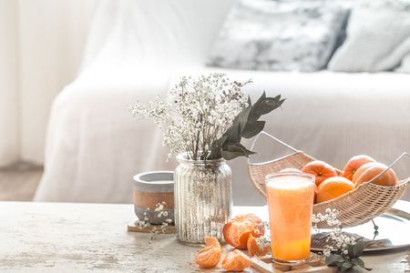 Freshly-grown organic fresh orange juice in the interior of the house, with a turquoise blanket and a basket of fruit. Healthy food. Vitamin Cの写真素材
