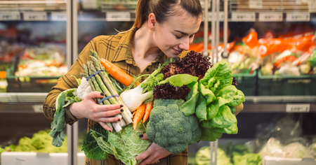 Woman in the supermarket. Beautiful young woman shopping in a supermarket and buying fresh organic vegetables. The concept of healthy eating. Harvestの写真素材