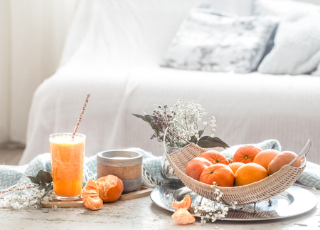 Freshly-grown organic fresh orange juice in the interior of the house, with a turquoise blanket and a basket of fruit. Healthy food. Vitamin Cの写真素材