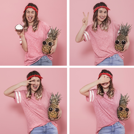 Collage with a young stylish woman with different emotions on her face with pineapple in her hands, isolated on a pink background, the concept of emotionsの写真素材