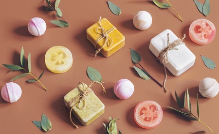 Flat composition with cosmetic products on a colored background. Spring flowers, soap, bath bomb. View from the top banner. Place for textの写真素材