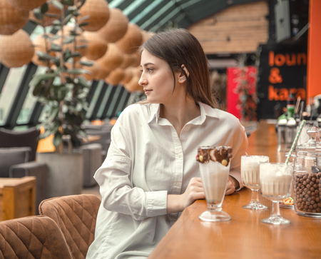 Beautiful Young girl drinking milk chocolate cocktail in a cafe. Leisure in the restaurantの写真素材