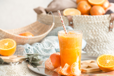 Freshly-grown organic fresh orange juice in the interior of the house, with a turquoise blanket and a basket of fruit. Healthy food. Vitamin Cの写真素材