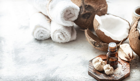 still life with coconut oil in a bottle and fresh coconut on a light background, spa therapy conceptの写真素材