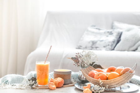 Freshly-grown organic fresh orange juice in the interior of the house, with a turquoise blanket and a basket of fruit. Healthy food. Vitamin Cの写真素材
